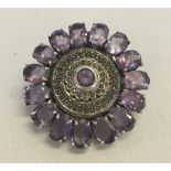 A large circular silver, marcasite & amethyst brooch.