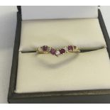 A 9ct gold wishbone dress ring set with 4 rubies and 3 cubic zirconias. Size P total weight 1.1g.