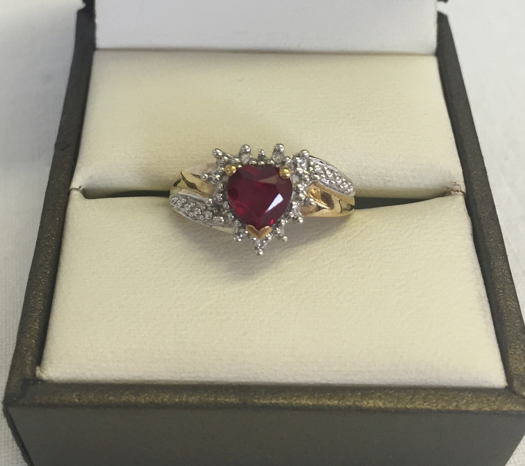 A 9ct gold created ruby and diamond dress ring in a heart shap. Size L total weight 2.1g.