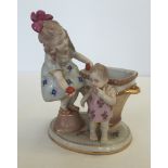 A ceramic figurine of a small girl and baby.