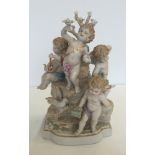 A large ceramic figurine depicting 4 cherubs on a tree stump. Approx 20 x 34cm.