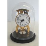 A modern brass clock on a round marble base with glass dome lid, approx 17cm high.