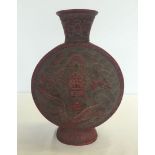 A Chinese moon shaped red vase with dragon decoration, approx 27cm high.