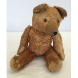 A golden brown straw filled German teddy bear, 12 inches tall. Brought over from Germany for