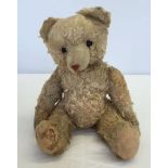 A light blonde straw filled German teddy bear, 12 inches tall. Brought over from Germany for