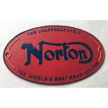 A red painted cast iron Norton Motorcycle wall plaque.