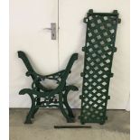 A pair of cast iron bench ends together with bench back panel, painted green.