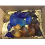 A quantity of glass eggs. 7 blue and 9 with amber swirl decoration.