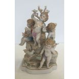 A large ceramic figurine depicting 4 cherubs on a tree stump. Approx 20 x 34cm.