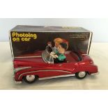 A large tin plate boxed car with battery operated lights and sounds.