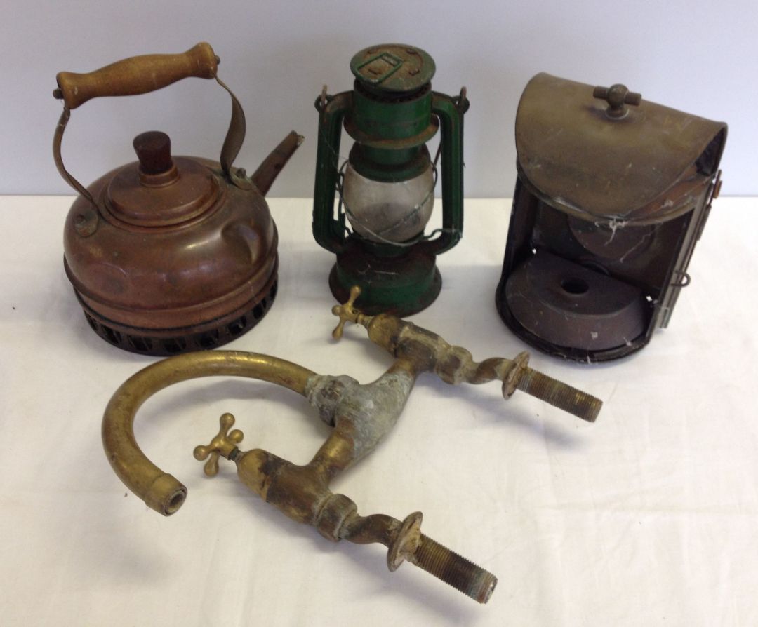 Mixed metalware items comprising brass taps, copper kettle, tilley lamp, and brass lamp.