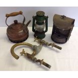 Mixed metalware items comprising brass taps, copper kettle, tilley lamp, and brass lamp.