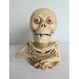 A cast iron painted skeleton money bank.