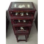 A Chinese nest of 4 red lacquer tables with glass tops with applied mother of pearl figures and gilt