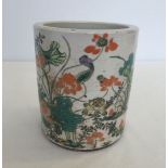 A chinese ceramic brush pot with water lily design.