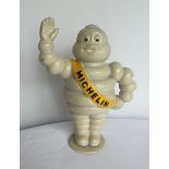 A waving Michelin Man money bank - reproduction cast iron.