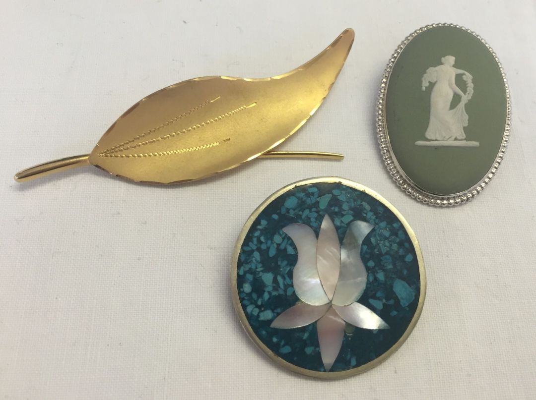 3 vintage brooches: 1) An oval Wedgwood green jasper ware brooch. 2) A rolled gold leaf design