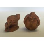 2 carved wood netsukes, a hen and a chick together with a bat laying on a peach.