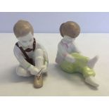 A pair of ceramic figures, a boy and girl, A. Quincum Budapest.