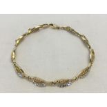 A 14ct gold bracelet. Pretty design in yellow and white gold. Approx 17cm long. Weight approx 6.9g.