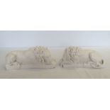 A pair of white marble laying lions. Approx 32 x 13cm.