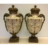 A Pair of large ceramic urns on brass pedestals with brass serpent handles.