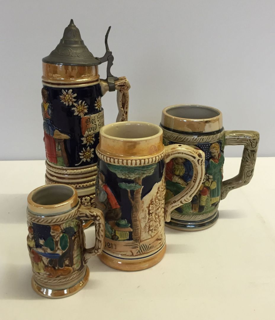 A small collection of ceramic tankards to include a musical lidded stein.