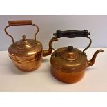 2 small copper kettles one with copper handle and one with a wooden handle.