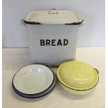 A quantity of enamel ware items comprising: Bread bin, 3 plates & a lidded casserole dish.