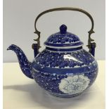 Oriental flower design blue & white teapot with metal handle.