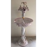 A large decorative ceramic water feature in white and pink with flower decoration by Soenzon,