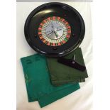 A boxed vintage roulette wheel together with green baize playing mat.