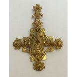 A large gold coloured 'Castlecliff' cross shaped pendant with Aztec style design. Designed by