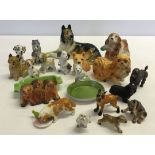 A collection of small ceramic dogs to include Sylvac, Wade & Beswick.