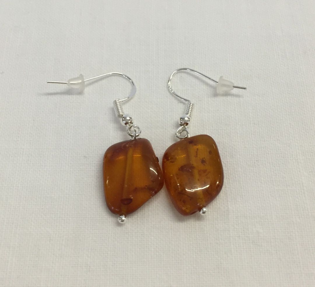 A pair of amber drop earnings marked 925.