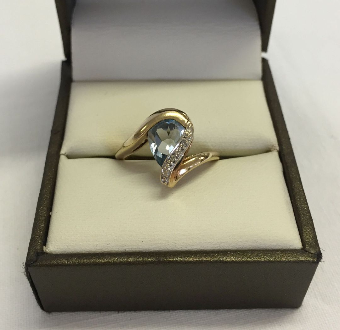 Unusual design blue topaz & diamond ladies ring. Large pear cut stone approx 0.75ct. Hallmarked