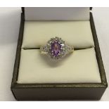 9ct gold ladies dress ring set with central oval amethyst surrounded by small diamonds. Size