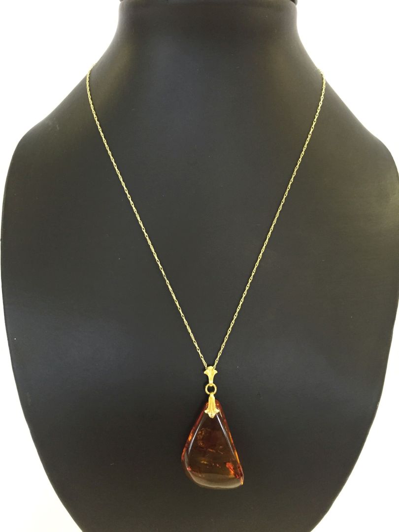 A Baltic amber drop pendant on a 18" 9ct gold chain.