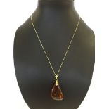 A Baltic amber drop pendant on a 18" 9ct gold chain.