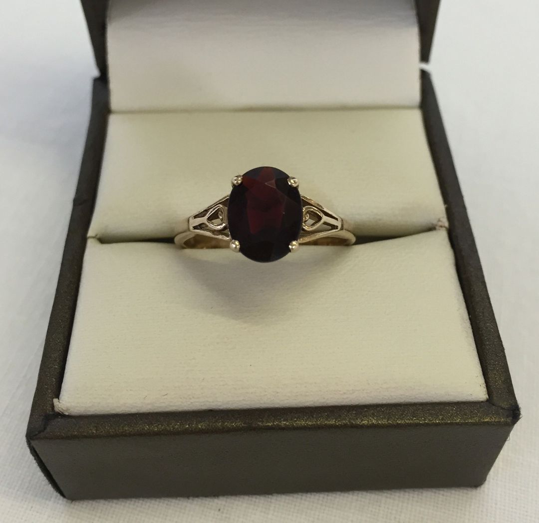9ct gold ring set with an oval garnet. Weight approx 2.2g, size P.