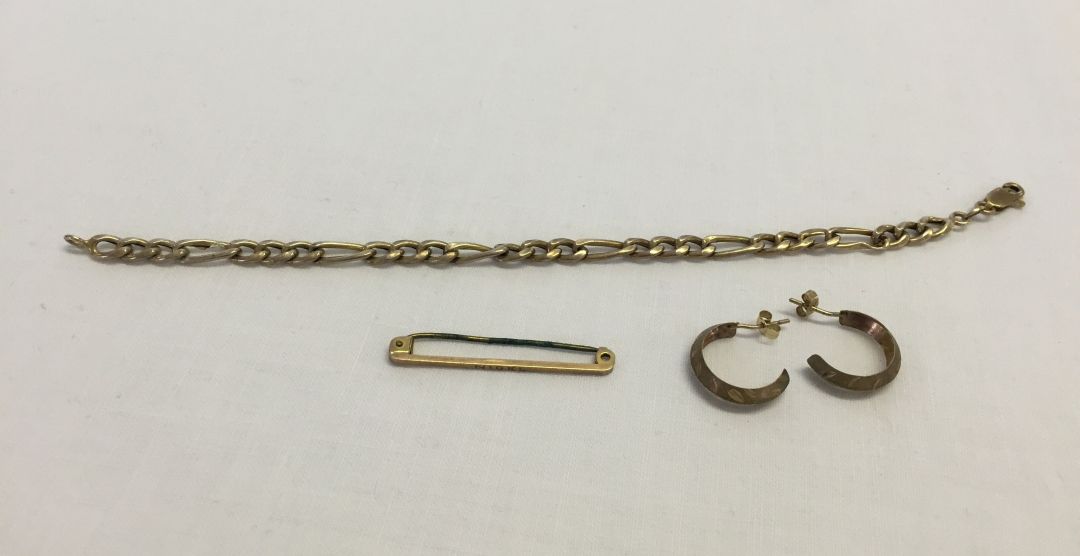 A small collection of 9ct gold items comprising a pair of earrings, link bracelet, and tie pin (