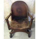 A vintage leather tub chair with tooled horse decoration to back.