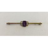 A vintage 9ct gold bar brooch with central amethyst stone.