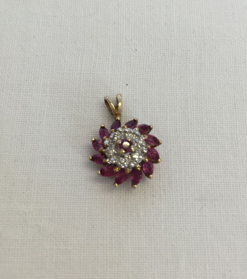 9ct gold pendant set with rubies and diamonds. Total weight approx 1.7g. Approx 1.4cm across x 2cm