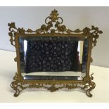 An ornate gilt framed table mirror with bevel edged glass 27 x 28cm.