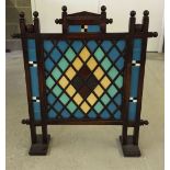 A vintage oak firescreen with coloured tile inserts.
