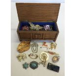 A small wooden casket containing vintage brooches including natural stones & enamelled pieces.