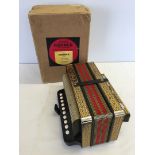 A vintage Hohner single row button accordian with steel reeds in original box.