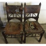 A pair of antique leather chairs for restoration. Tooled coat of arms to back.