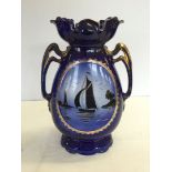 A large blue two handled vase with sailing boat decoration 38cm tall.